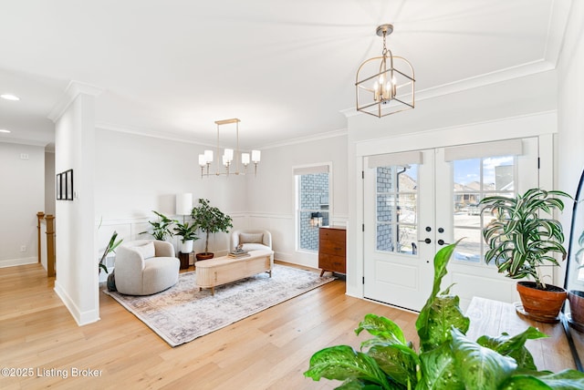 entrance foyer featuring baseboards, ornamental molding, light wood-type flooring, a chandelier, and recessed lighting