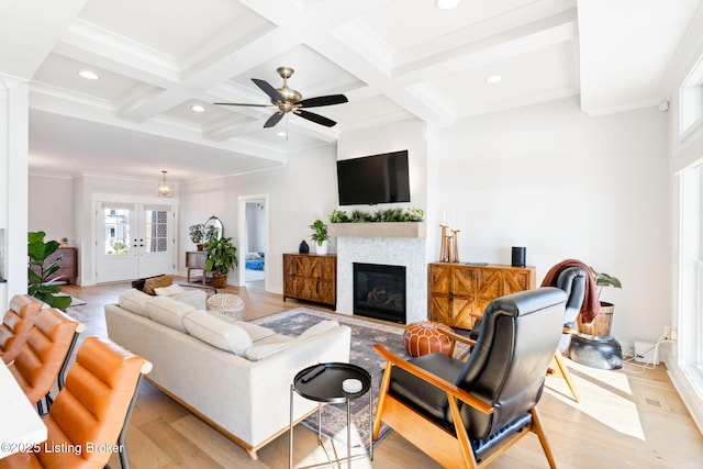 living area with light wood-style flooring, coffered ceiling, and beam ceiling