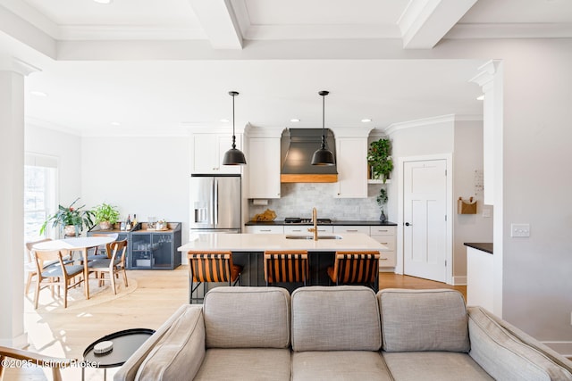 kitchen with pendant lighting, beam ceiling, stainless steel refrigerator with ice dispenser, custom range hood, and white cabinets