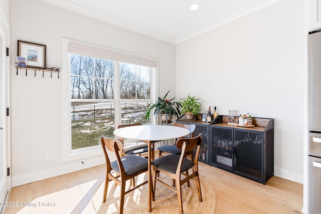 dining space with baseboards, recessed lighting, light wood-style flooring, and crown molding