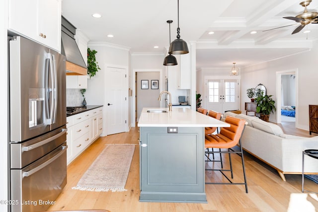 kitchen featuring hanging light fixtures, white cabinetry, appliances with stainless steel finishes, and a sink