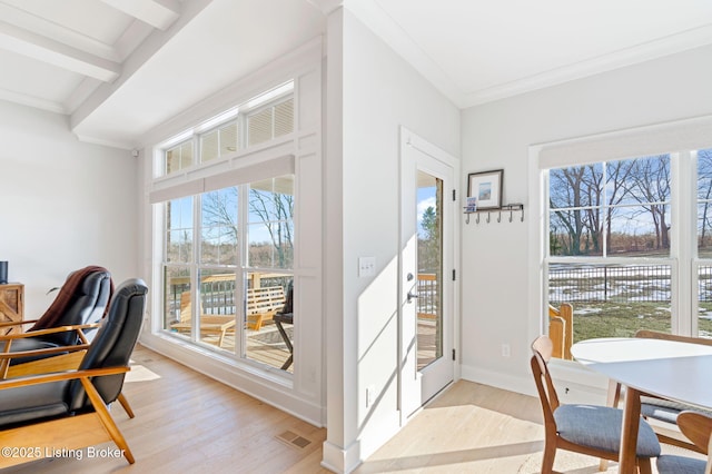 entryway featuring visible vents, baseboards, ornamental molding, a water view, and light wood-style floors