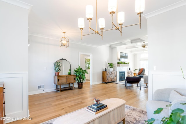 living room with a glass covered fireplace, a healthy amount of sunlight, visible vents, and wood finished floors