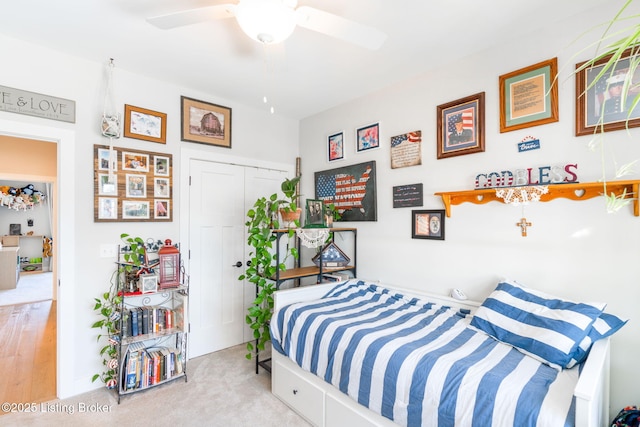 bedroom with a closet, a ceiling fan, and light colored carpet