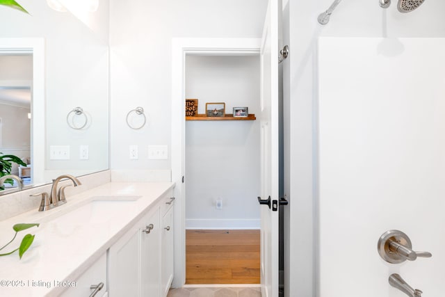 full bathroom with vanity, baseboards, and bathing tub / shower combination