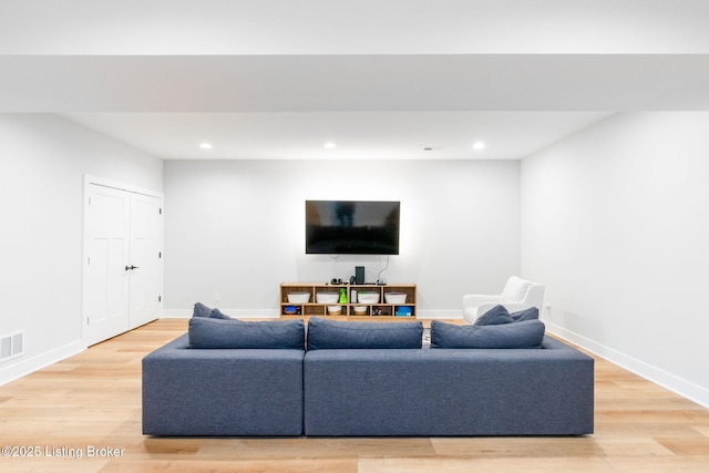 living area with baseboards, visible vents, light wood-style flooring, and recessed lighting