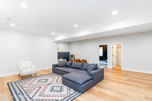 living room with baseboards, wood finished floors, and recessed lighting