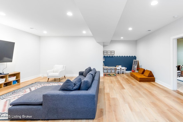 living area featuring baseboards, wood finished floors, and recessed lighting