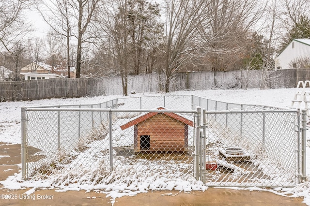 yard covered in snow with a gate and fence