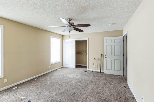 unfurnished bedroom featuring a textured ceiling, a ceiling fan, baseboards, a closet, and carpet