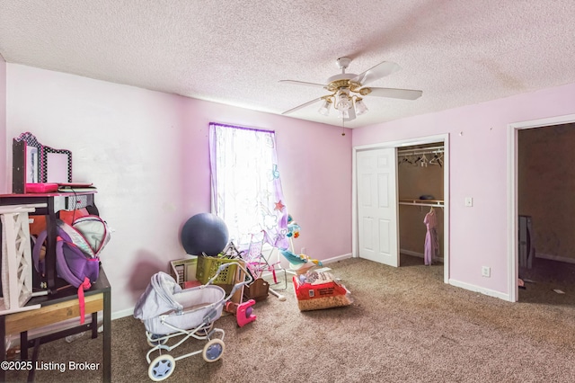 playroom featuring a textured ceiling, carpet, a ceiling fan, and baseboards