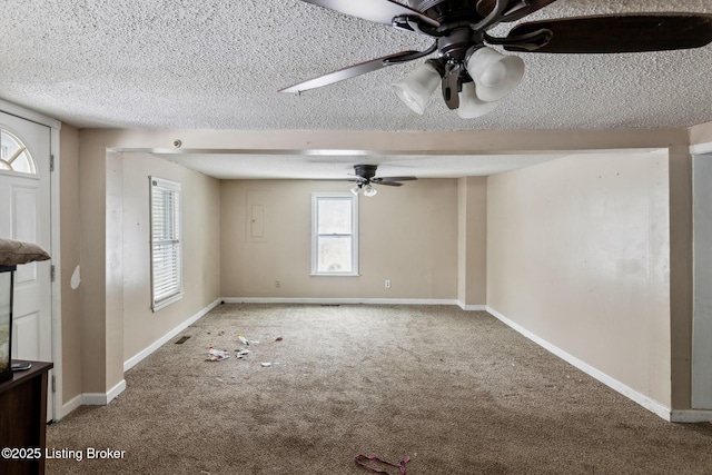 carpeted empty room featuring ceiling fan, baseboards, and a textured ceiling