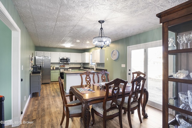 dining space featuring a notable chandelier, dark wood-type flooring, an ornate ceiling, and baseboards