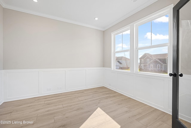 unfurnished room featuring ornamental molding, recessed lighting, wainscoting, and light wood finished floors