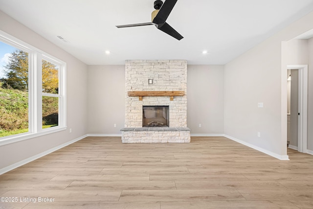 unfurnished living room featuring baseboards, a fireplace, and light wood finished floors