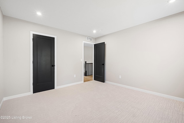 unfurnished bedroom with recessed lighting, light carpet, and baseboards