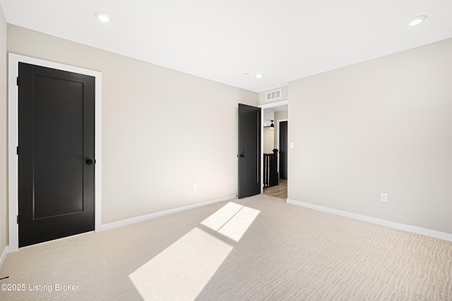 empty room featuring recessed lighting, light carpet, visible vents, and baseboards