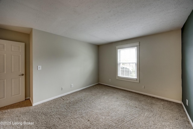 empty room featuring light carpet, a textured ceiling, and baseboards