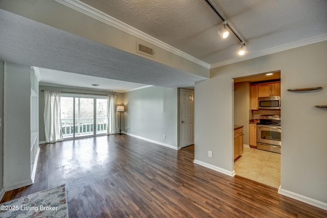 unfurnished living room with a textured ceiling, light wood-type flooring, visible vents, and crown molding