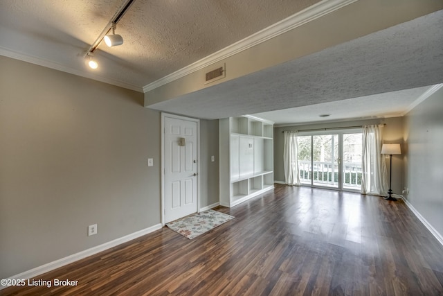 unfurnished living room with baseboards, visible vents, dark wood-style floors, a textured ceiling, and crown molding