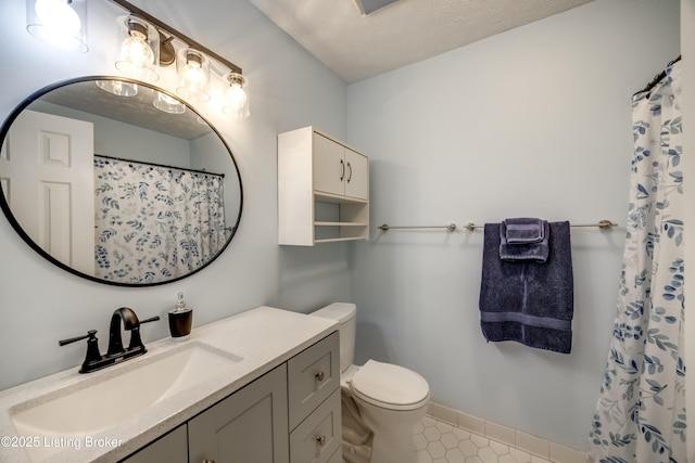 bathroom with toilet, tile patterned floors, vanity, baseboards, and a shower with curtain