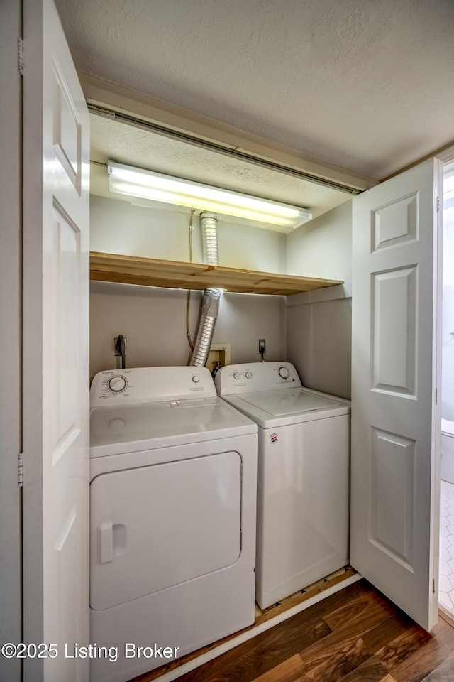 clothes washing area featuring laundry area, a textured ceiling, separate washer and dryer, and dark wood-style flooring