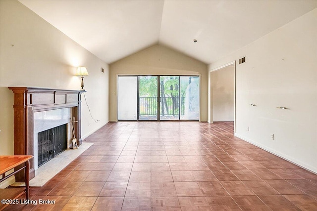 unfurnished living room featuring visible vents, baseboards, lofted ceiling, a premium fireplace, and light tile patterned flooring