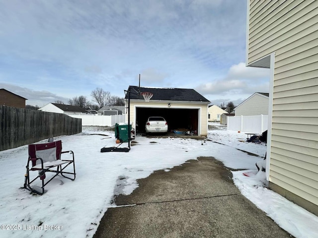 yard layered in snow with a garage and fence