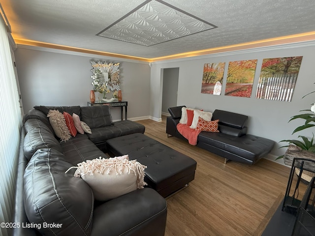 living area featuring a textured ceiling, baseboards, and wood finished floors