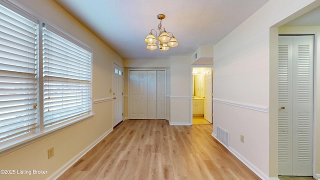 unfurnished bedroom with light wood-style flooring, baseboards, and visible vents