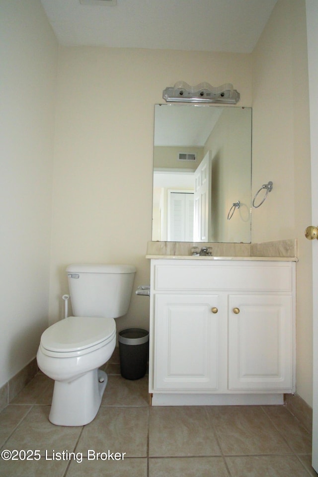 half bath with tile patterned flooring, visible vents, toilet, and vanity