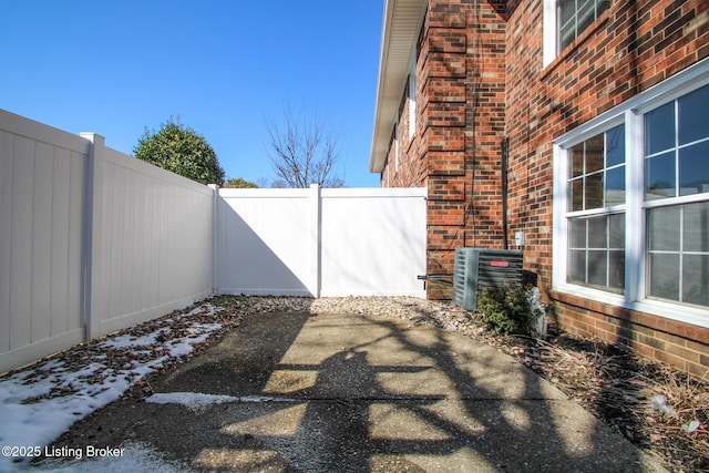 view of patio featuring central AC unit and fence