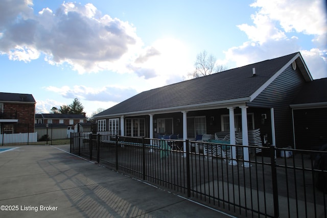 exterior space featuring a shingled roof and fence