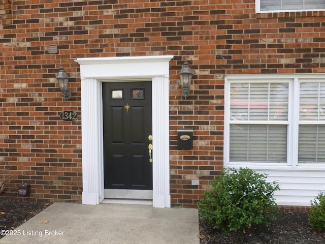 doorway to property featuring brick siding