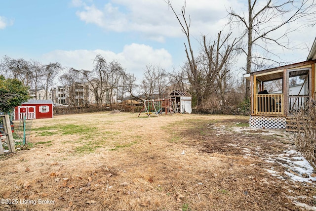 view of yard with a shed, a playground, and an outdoor structure