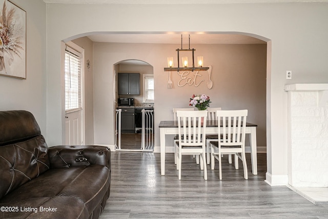 dining room featuring baseboards, a chandelier, and wood finished floors