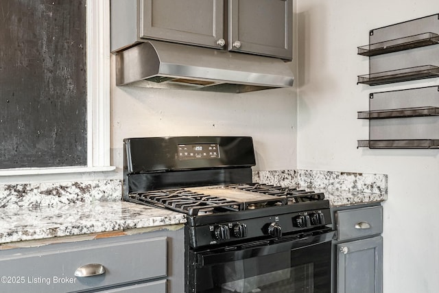 kitchen featuring black gas range oven, gray cabinets, light countertops, under cabinet range hood, and open shelves