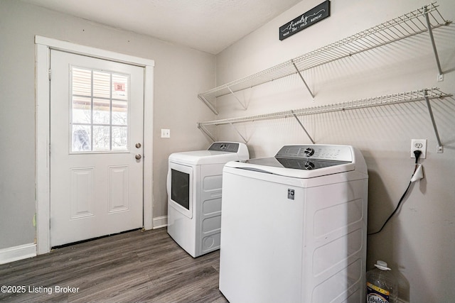 laundry room with dark wood-style flooring, laundry area, baseboards, and washing machine and clothes dryer