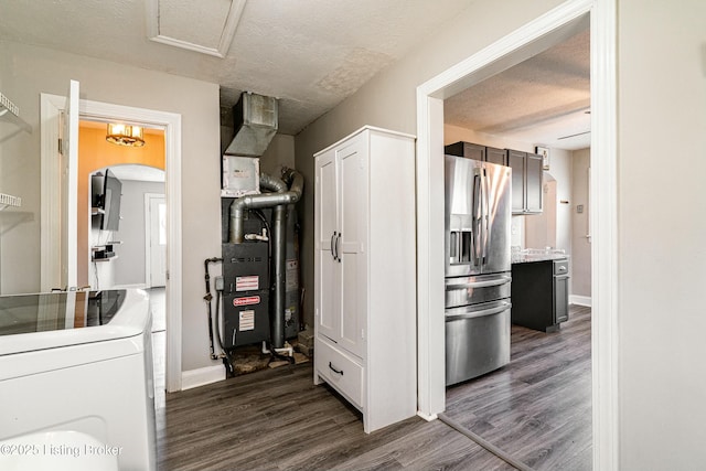 kitchen with stainless steel fridge, arched walkways, dark wood-style floors, light countertops, and a textured ceiling