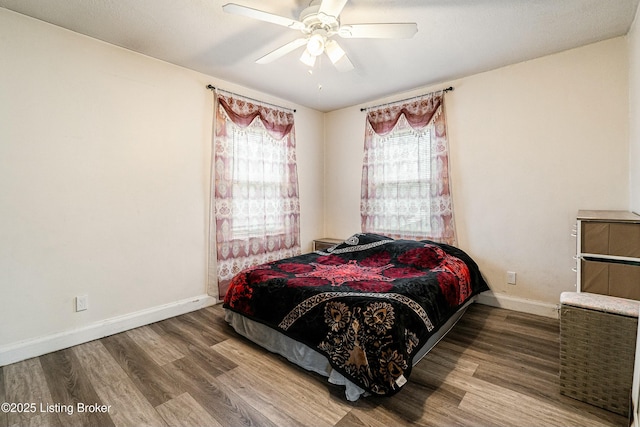 bedroom featuring ceiling fan, wood finished floors, and baseboards