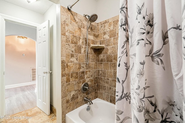 bathroom featuring shower / bathtub combination with curtain and visible vents