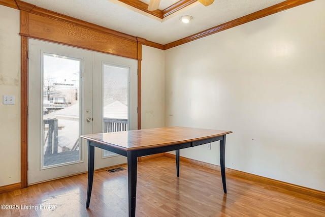 office with visible vents, ornamental molding, a textured ceiling, french doors, and light wood-type flooring