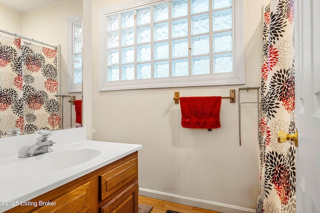 full bathroom featuring wood finished floors, vanity, and baseboards