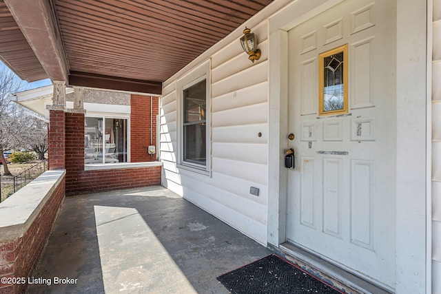 view of exterior entry featuring covered porch