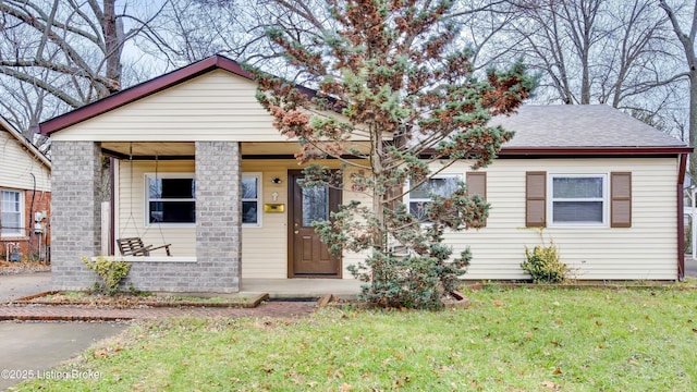 bungalow with a shingled roof and a front yard