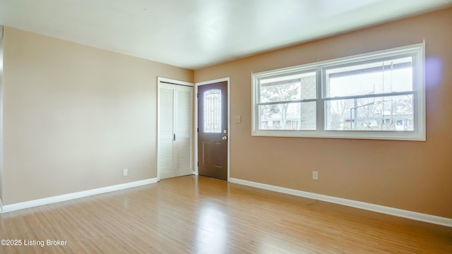 entryway featuring plenty of natural light, light wood-style flooring, and baseboards