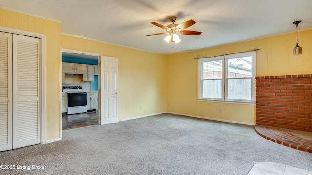 interior space with a ceiling fan, carpet flooring, and crown molding