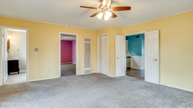 unfurnished bedroom featuring ensuite bathroom, ornamental molding, a closet, and light colored carpet