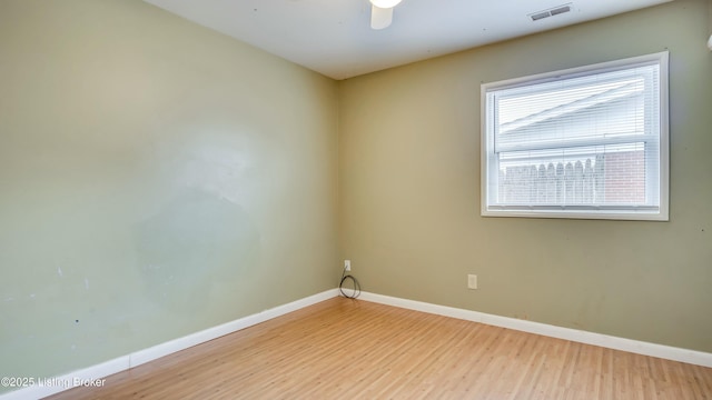 unfurnished room with light wood-style flooring, visible vents, and baseboards