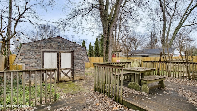 deck featuring an outbuilding, a fenced backyard, and a storage shed